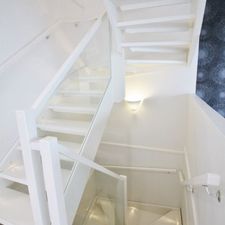 Valkoiset portaat lasikaiteilla ja valoilla
